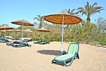 Liegestühle und Sonnenschirme am Strand