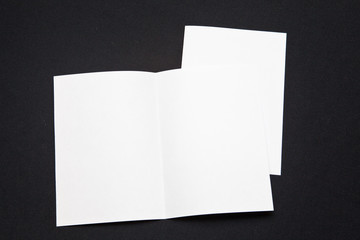 folded sheets of paper on a black background. layout