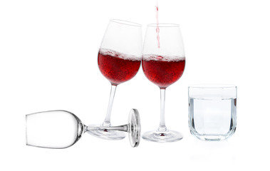 Poured red wine with drinking water on white background