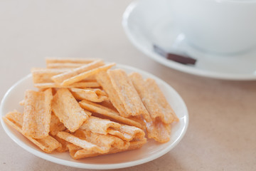 Snack on white plate with coffee cup