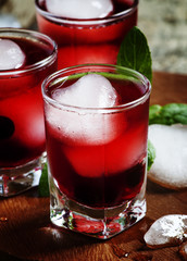 Red berry juice with ice in the shape of hearts, selective focus