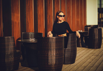 Portrait of young pretty woman sitting in street cafe