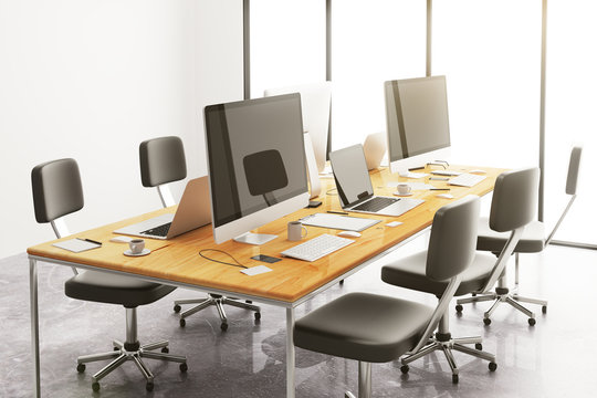 wooden conference table with office accessories and computers