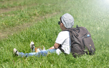  A small boy sitting on the grass at the park