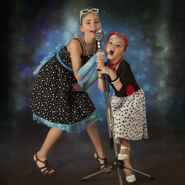 Rockabilly girls posing with vintage microphone