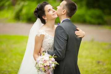 Closeup portrait of newly married couple hugging at park