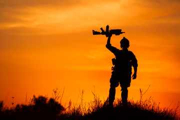 Silhouette of military soldier or officer with weapons at sunset