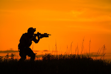 Silhouette of military soldier or officer with weapons at sunset