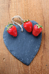 drei Erdbeeren auf Schieferherz