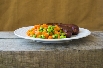 Sausages with peas and carrots