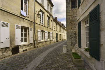 Fototapeta na wymiar Rue pavée à volets Alphonse Cardin de Crépy-en-Valois (60800), département de l'Oise en région Hauts-de-France, France 