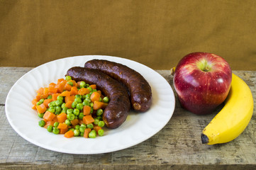 Sausages on a plate and fruits