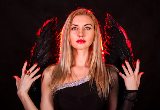 Beautiful young woman with black angel wings