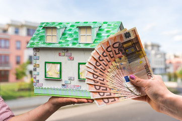 Real estate agent holding model house from paper and new propert