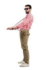 Funny eccentric hipster pulling suspenders of his pants 