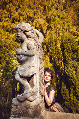 Portrait of sensual brunette in veil by the sculpture