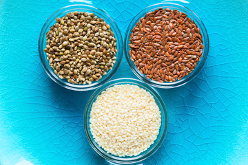 Flax, sesame, and hemp seeds in glass bowls