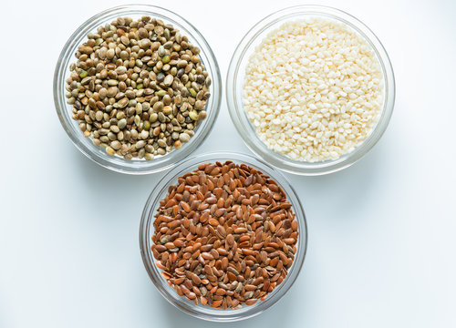 Flax, sesame, and hemp seeds in glass bowls