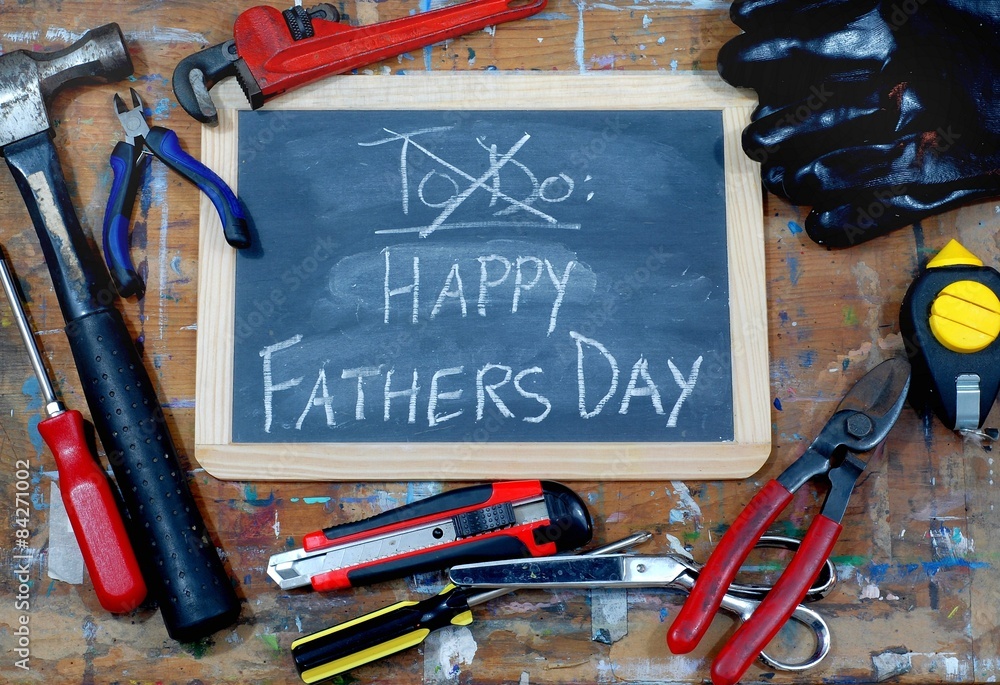 Wall mural Fathers day image with blackboard and tools on a stained table