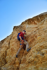 man climbing on yellow rock