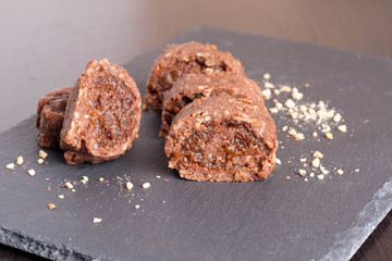 chocolate swiss roll with fruit jam on black background