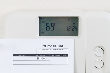 Utility bill with heating thermostat on wall