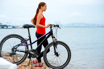 Fototapeta na wymiar Woman with bicycle on the beach