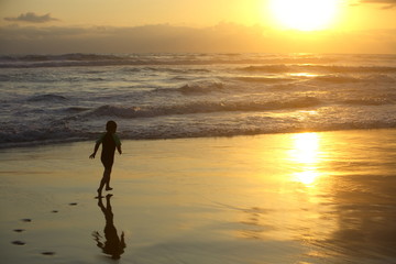 Fototapeta na wymiar Boy running on the beach at sunset