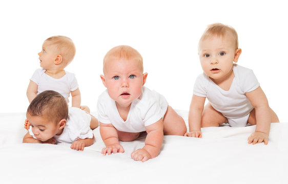 Curious looking babies crawl in a row together