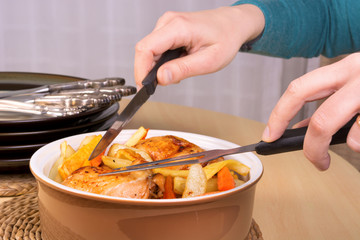 Close up of the hands ready to serve roasted chicken legs and ve