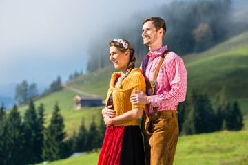 Paar in Tracht im Urlaub auf Alpen Berggipfel