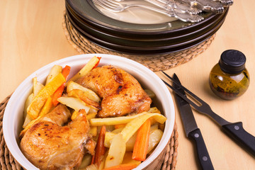 Close up of roasted chicken legs and vegetables in a casserole,