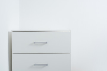 white wall and a chest of drawers