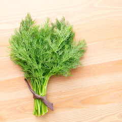 Fresh dill on a light wooden background