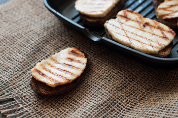 Crostini with fried cheese on the grill