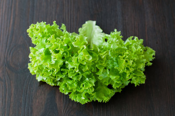 fresh green salad leaves (lettuce) on black wooden table