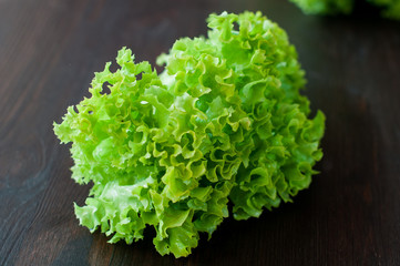 Obraz na płótnie Canvas fresh green salad leaves (lettuce) on black wooden table