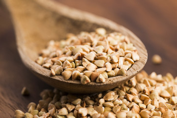 Buckwheat with a spoon on a wooden boards background