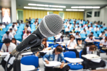 A microphone with blur background of many students learning
