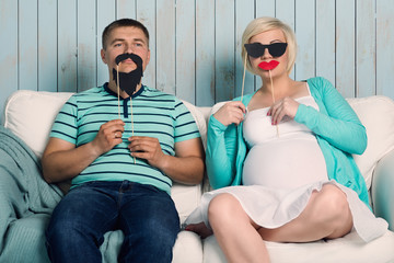 Pregnant couple with false mustaches