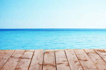 Naklejka na ściany i meble Wooden pier with blue sea and sky background