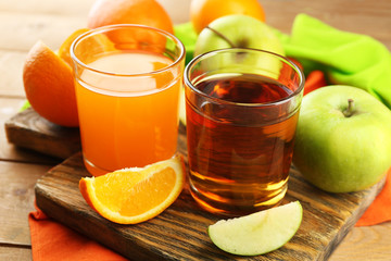 Assortment of healthy fresh juices and fruits on wooden table background