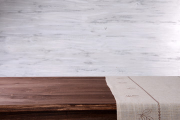 Empty wooden table with napkin and light background