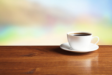 Cup of coffee on table on bright background