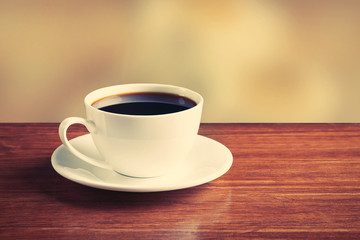 Cup of coffee on table on bright background