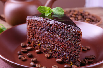 Delicious chocolate cake with mint on plate on table close up