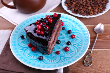 Delicious chocolate cake with berries on plate on table close up