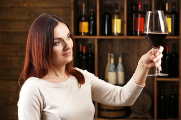 Young woman tasting wine in cellar