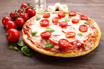 Delicious pizza with cheese and cherry tomatoes on wooden table, closeup