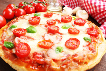Delicious pizza with cheese and cherry tomatoes on wooden table, closeup